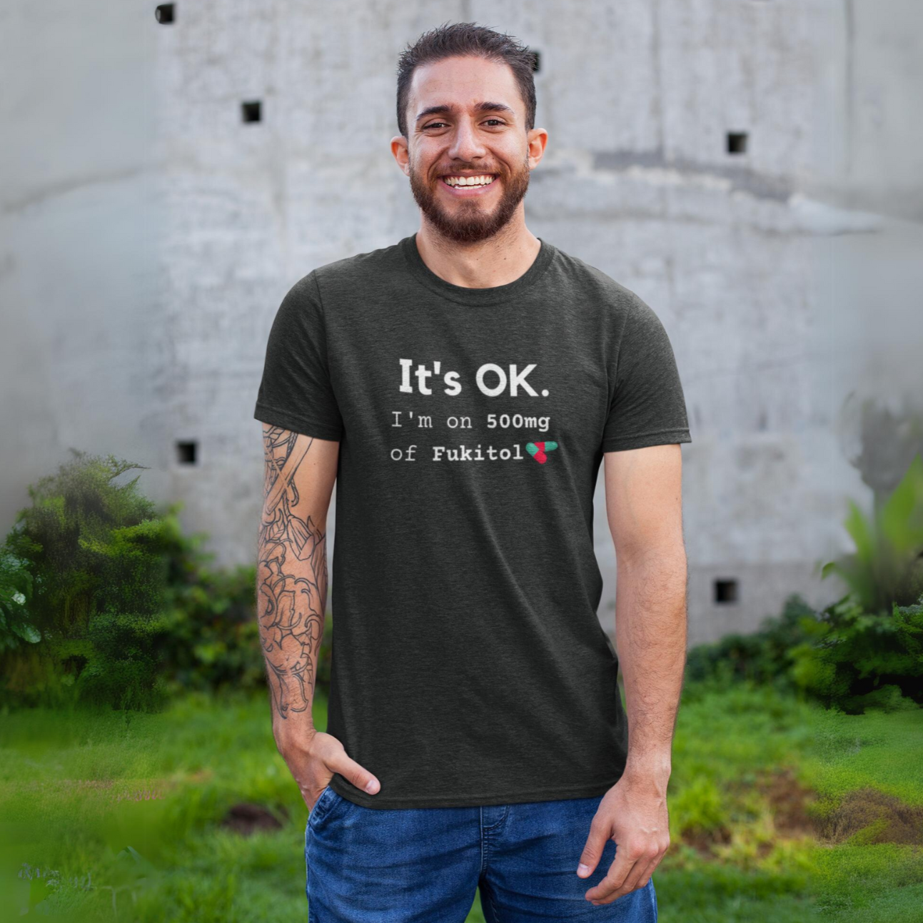 Funny workout shirt with text I'm on 500mg of fukitol, tee in dark grey heather almost black worn by a smiling man with a tattooed arm