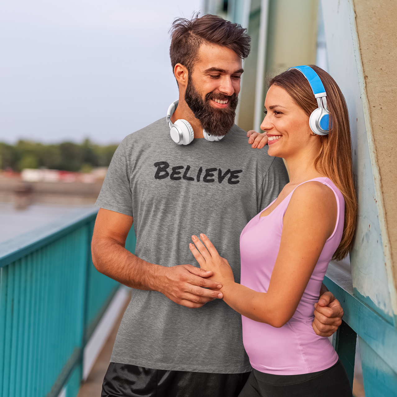 Exercise-t-shirt-with-word-Believe-on-a-man-with-a-woman-posing-on-a-bridge