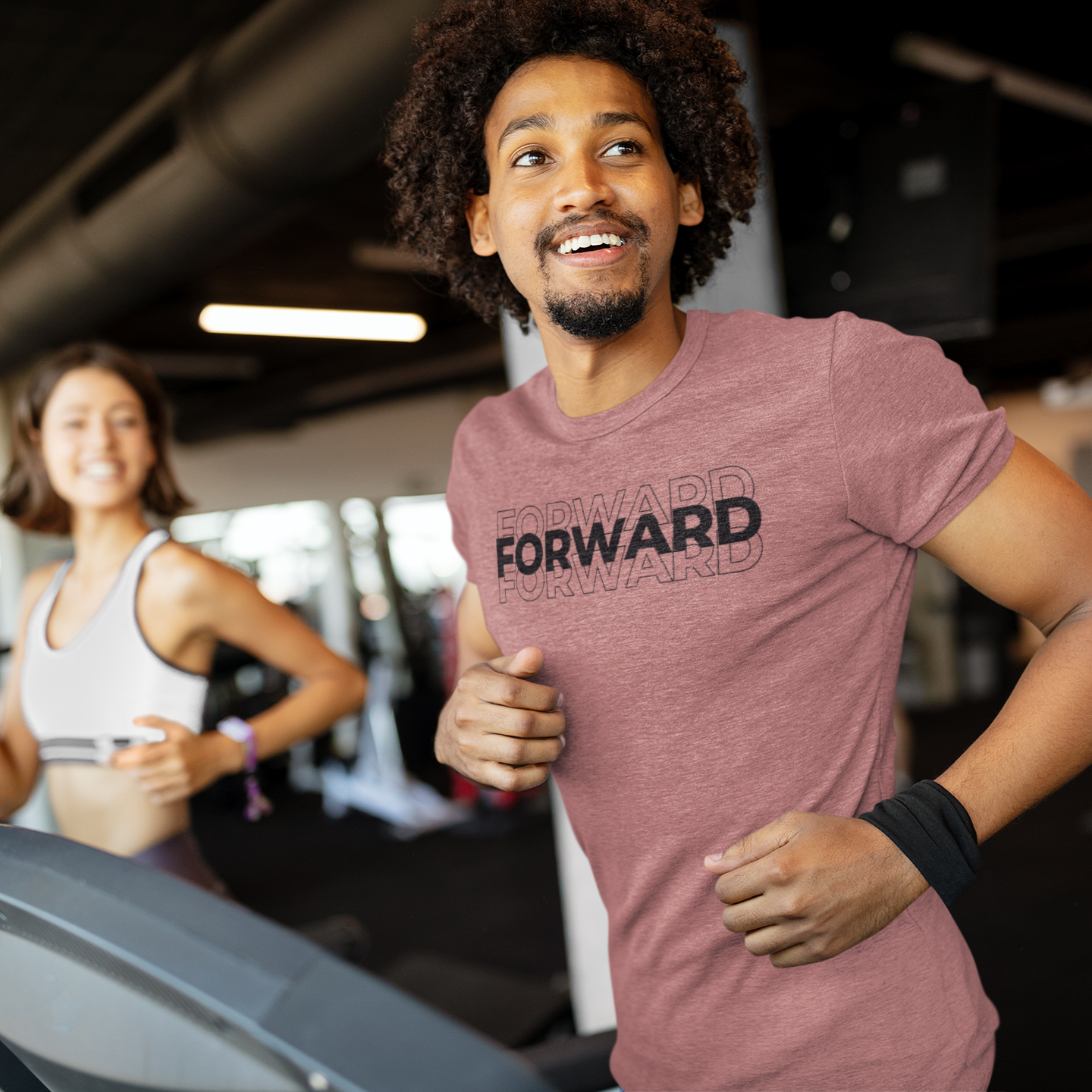 Motivational workout t-shirt with text Forward worn by a fit man jogging on a treadmill at the gym