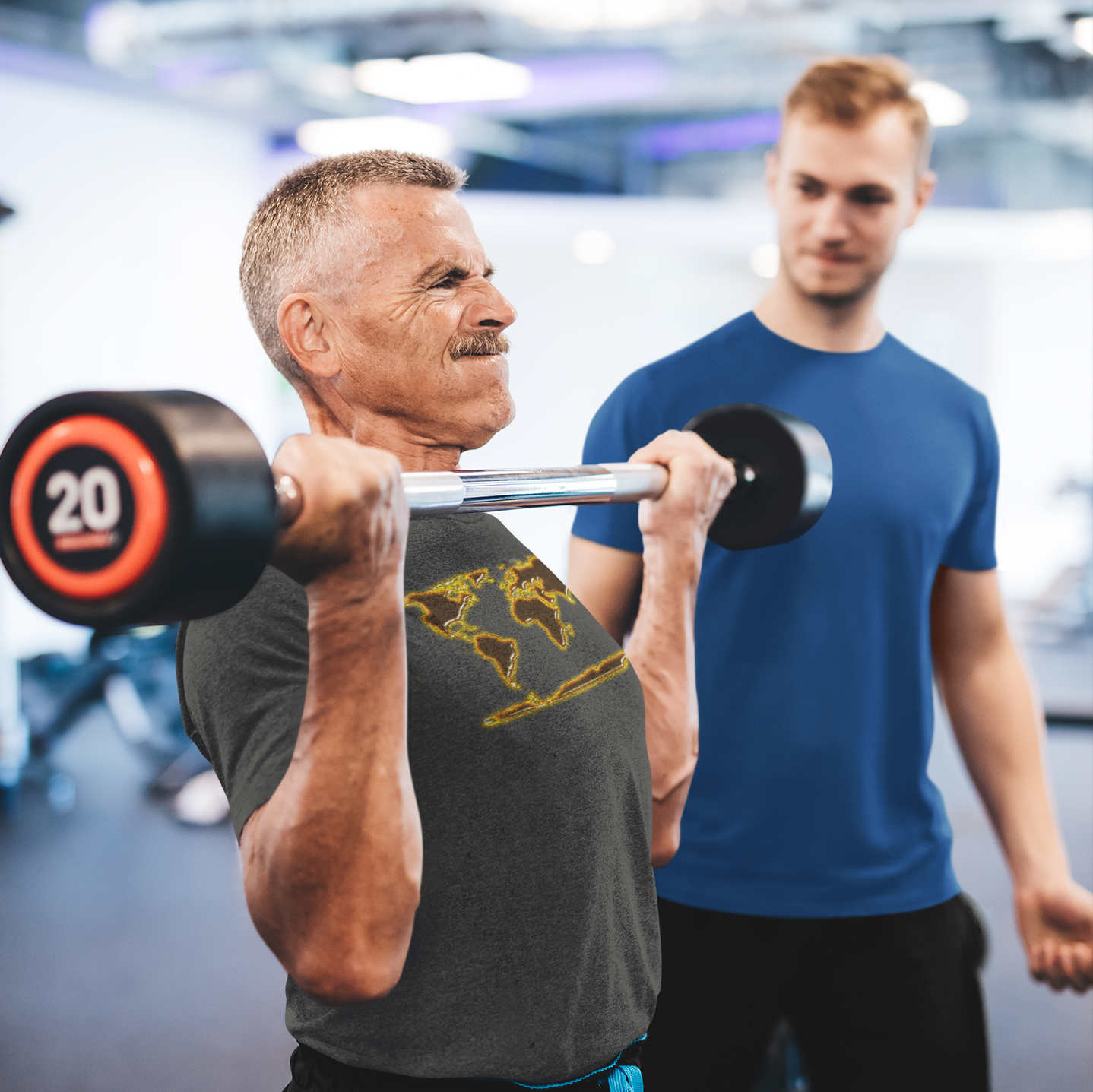 Motivational gym shirt with a golden world map worn by a man lifting weights at the gym